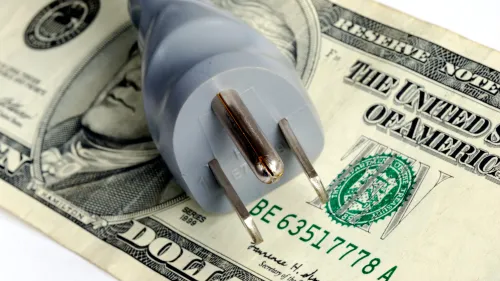 Photo of an electrical plug on top of a U.S. twenty dollar bill.