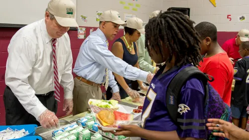 Photo of adults providing free summer meals to students.