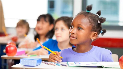 Child sitting at desk learning with classmates