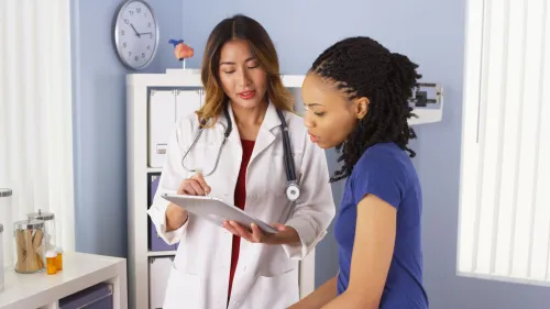 A female doctor and a patient are reviewing patient information together
