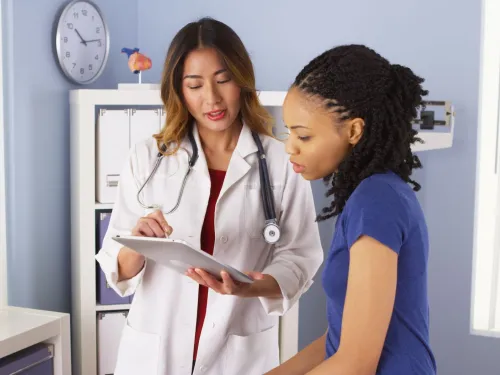A female doctor and a patient are reviewing patient information together