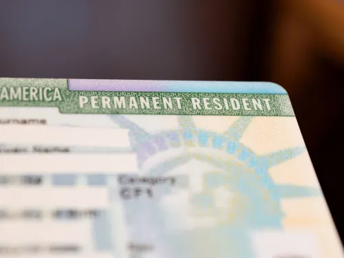 A permanent residency card with the names blurred for confidentiality.
