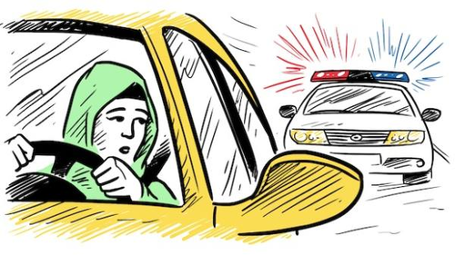 A woman wearing a green headscarf is driving a yellow car, looking worried as she glances in the rearview mirror. Behind her, a police car with flashing red and blue lights is approaching.