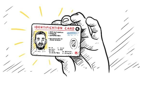 A hand is holding an identification card. The card has a photo of a man, along with personal details such as name, date of birth, and identification number. The word 'IDENTIFICATION CARD' is prominently displayed at the top.