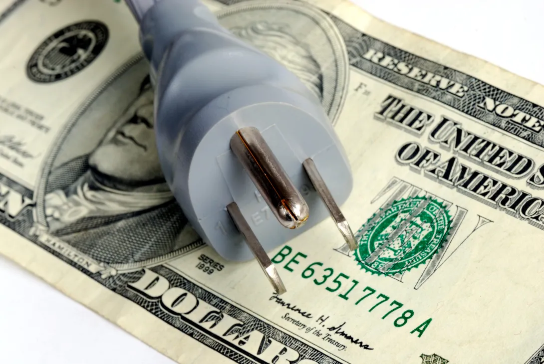 Photo of an electrical plug on top of a U.S. twenty dollar bill.