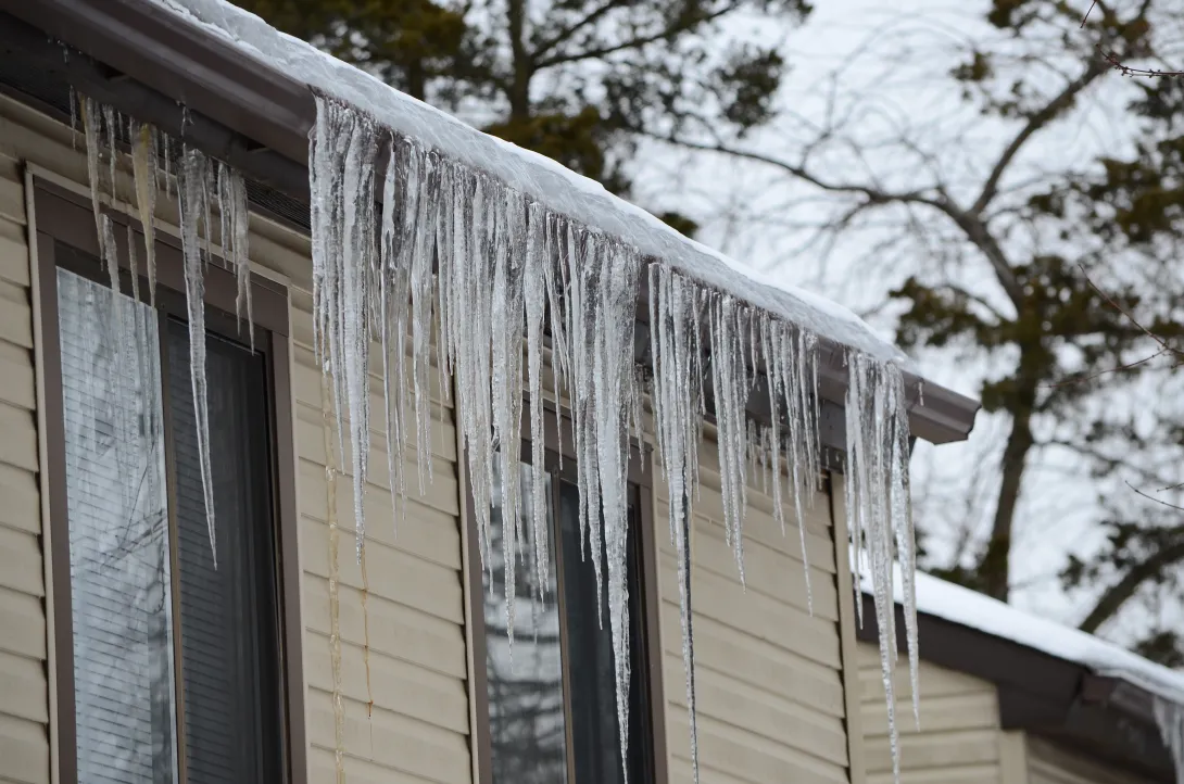 Icicles form from the roof of an apartment during freezing conditions